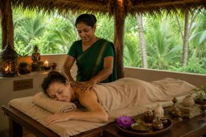 a woman giving a man a massage on a bed at Good Karma Villa in Bentota