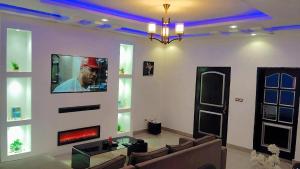 a living room with a couch and a tv on a wall at Apparemment PARC DES PRINCES in Yaoundé