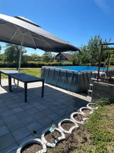 a picnic table with an umbrella next to a pool at Breze Away in Tuzla