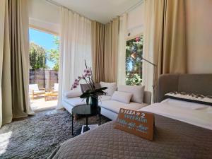 a hotel room with a bed and a couch and a window at Villa Del Mar with Heated Pool & Spa in Mazotos +158 photos