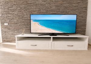 a television on a white dresser in a living room at Eqinox apartments in Mamaia Sat/Năvodari