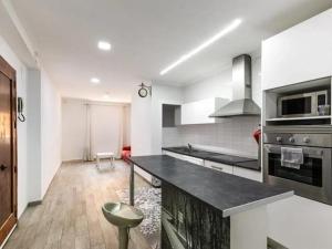a kitchen with white walls and a black counter top at Valencia Room in Cuart de Poblet