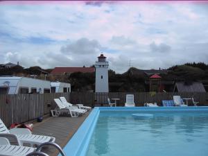 a lighthouse with a swimming pool and a light house at Lønstrup Egelunds Motel in Lønstrup