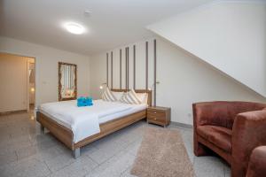 a bedroom with a bed and a chair at Ferienwohnung Cella in Zell an der Mosel