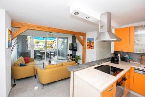 an open kitchen and living room with orange cabinets at Ferienwohnung Cella in Zell an der Mosel