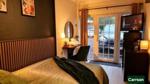 a bedroom with a bed and a desk and a television at The Hideout Middlesbrough Great Location in Middlesbrough