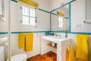 a bathroom with a sink and a toilet and a mirror at Villa Atréju in Cómpeta +59 photos