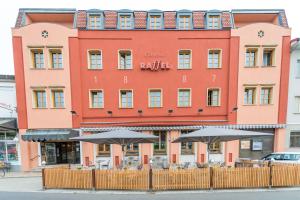 a large orange building with umbrellas in front of it at Hotel Raffel in Jennersdorf