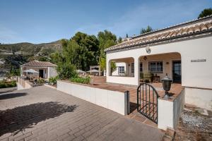 a house with a gate and a patio at Villa Atréju in Cómpeta