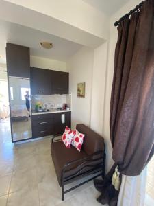 a living room with a couch and a kitchen at GoldenHill Studios&apartments in Skiathos