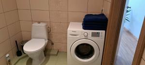 a bathroom with a washing machine and a toilet at Vita apartment in Vilnius