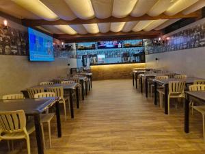 a dining room with tables and chairs and a bar at Peruibiza Pousada in Peruíbe
