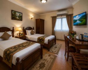 a hotel room with two beds and a desk at Kagera Breeze Resort in Mbarara