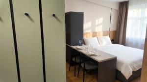 a hotel room with a bed and a small table at Axiom Suites - Nova 7 in KoÅ¡ickÃ© KÃºpele