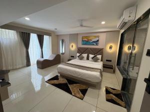a bedroom with a bed and a couch in it at Hotel Prominent Town in Ahmedabad