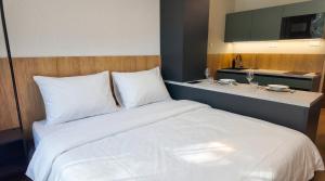 a large white bed in a hotel room with a counter at Axiom Suites - Nova 7 in KoÅ¡ickÃ© KÃºpele