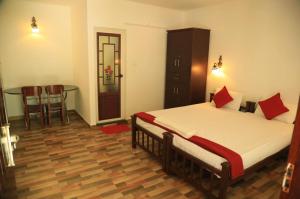 a bedroom with a bed and a table and chairs at Lakefront Beach Homes in Cherai Beach