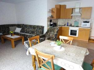 a living room with a table and a couch and a kitchen at Ferienwohnung Pfanne in Großkoschen