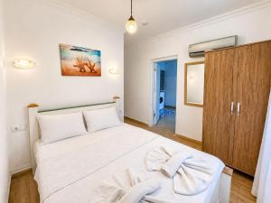 a bedroom with a white bed and a wooden cabinet at Eucalyptus Pension in Patara