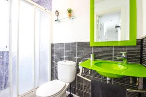 baño con lavabo verde y aseo en Apartamento Alvarez, en Málaga