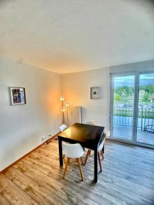 a dining room with a table and a balcony at La Résidence Urbaine in Mulhouse