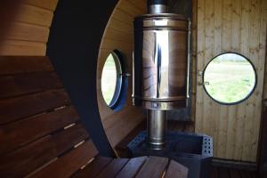 ein Holzofen in einer Hütte mit zwei Fenstern in der Unterkunft 100xZOOM in Pikla