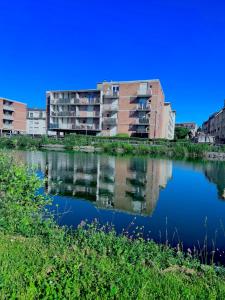 an apartment building next to a body of water at La Résidence Urbaine in Mulhouse