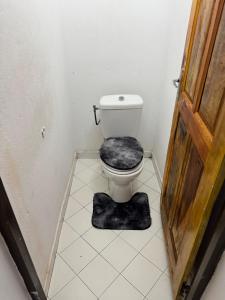 a bathroom with a toilet with a rug on the floor at Noble Villa in Abidjan +11 photos