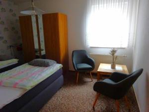 a bedroom with a bed and two chairs and a table at Ferienwohnung Pfanne in Großkoschen