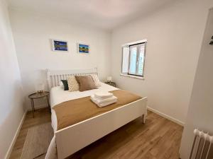 a white bedroom with a bed and a window at Casinha do Cercal in Cercal +28 photos