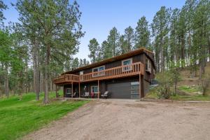 a house in the woods with a driveway at Prairie Creek Cabin Getaway in Rapid City