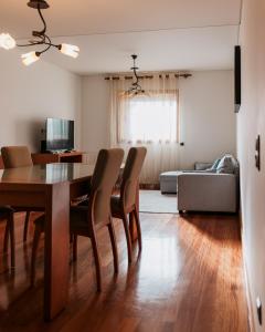 a dining room and living room with a table and chairs at La Guardia Apartment in Póvoa de Varzim