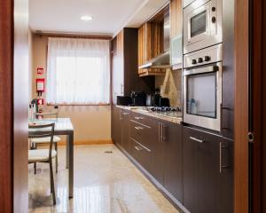 a kitchen with stainless steel appliances and a table at La Guardia Apartment in Póvoa de Varzim