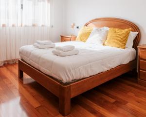 a bedroom with a large bed with towels on it at La Guardia Apartment in Póvoa de Varzim