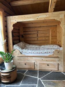 a large wooden bed in a wooden cabin at Liten hytte i Tinn in Notodden