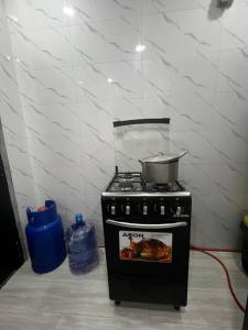 a kitchen with a stove with a pot on it at Private Bedroom with a private bathroom in Bolorunpelu