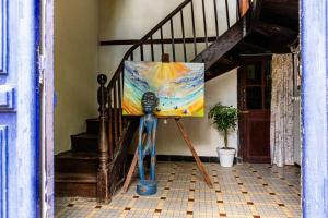 a painting on a stand in a room with a staircase at Les Portes Neuves! in Belloc-Saint-Clamens