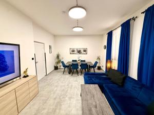 a living room with a blue couch and a table at Teplice Apartments in Teplice