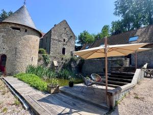 a wooden deck with an umbrella and a chair at Domaine de Godincthun in Pernes-lès-Boulogne