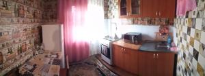 a small kitchen with a sink and a refrigerator at Квартира in Konotop