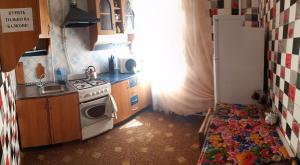 a small kitchen with a stove and a sink at Квартира in Konotop