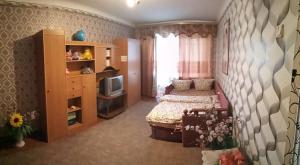 a small bedroom with a bed and a television at Квартира in Konotop