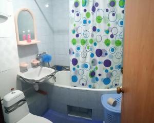 a bathroom with a shower curtain with a toilet and a sink at Квартира in Konotop