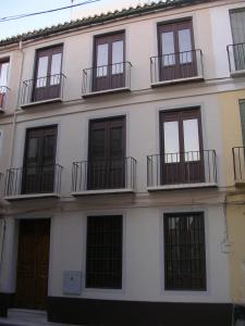 マラガにあるApartamento Alvarezの窓とバルコニーが備わる白い建物です。