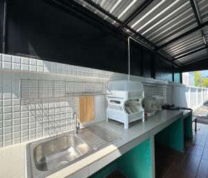 a kitchen counter with a sink and a stove at MUJI House Poolvilla Pattaya in Na Jomtien