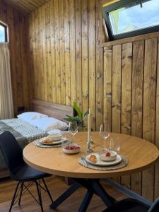 a wooden room with a table with food and wine glasses at Sosna Park Будиночки in Vynnychky