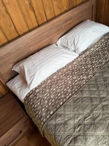 a small bed in a room with wooden walls at Sosna Park Будиночки in Vynnychky