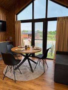 a table and chairs in a living room with a large window at Sosna Park Будиночки in Vynnychky +62 photos
