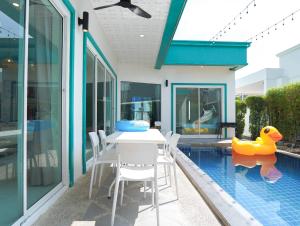 a house with a swimming pool with a table and a rubber duck at MUJI House Poolvilla Pattaya in Na Jomtien