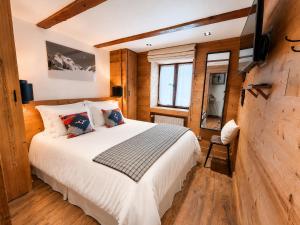 a bedroom with a bed and a tv on a wall at Chalet Pegulu in Puy-Saint-Vincent